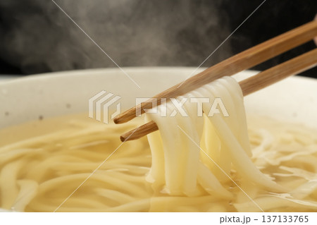 湯気の立った温かいうどんを箸で持ち上げる 137133765