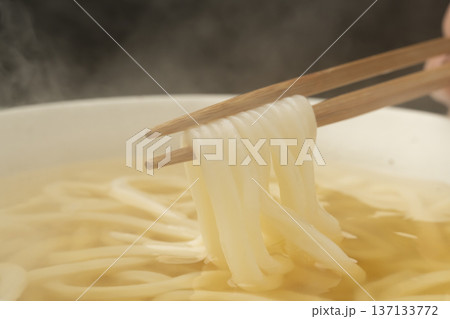 湯気の立った温かいうどんを箸で持ち上げる 137133772