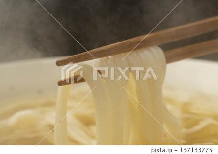湯気の立った温かいうどんを箸で持ち上げる 137133775