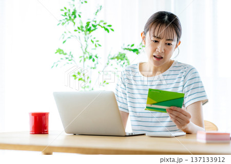 通帳を見てため息をつく主婦 通帳を見てため息をつく主婦 137133912