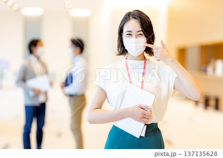 オフィスでマスクを着用している若い女性 オフィスでマスクを着用している若い女性 137135628