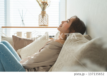 リビングのソファでリラックスするおしゃれな主婦のアジア人女性 137135652