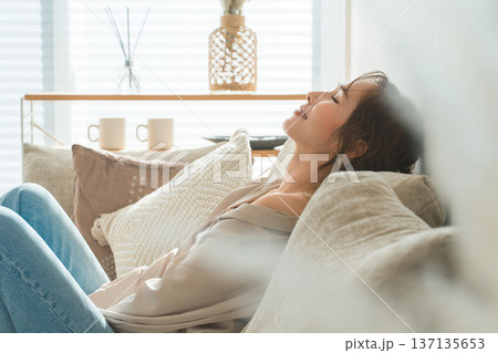 リビングのソファでリラックスするおしゃれな主婦のアジア人女性 137135653