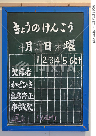 昭和の面影を残す木造校舎に掲げられた手書きの欠席者集計黒板 137135956