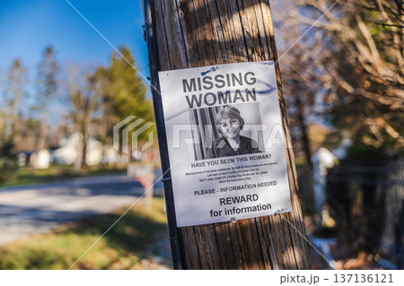 Missing woman reward poster attached to wooden utility pole in suburban neighborhood USA 137136121