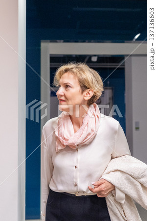 Woman standing in gallery interior examining framed artwork and pointing during exhibition visit Woman standing in gallery interior examining framed artwork and pointing during exhibition visit 137136603