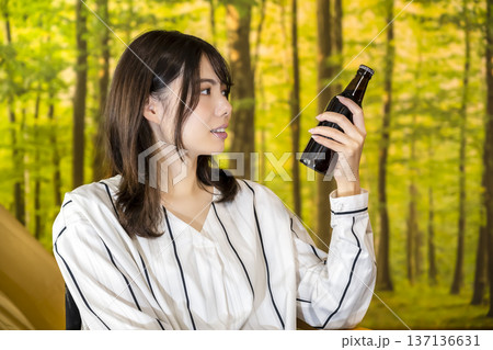 グランピング　キャンプでビールを片手に微笑む若い女性 137136631