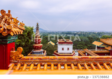 Summer Palace glazed roof tiles with sculptural ridge figures and layered eaves against clear sky, emphasizing imperial garden architecture, Beijing, China 137136662