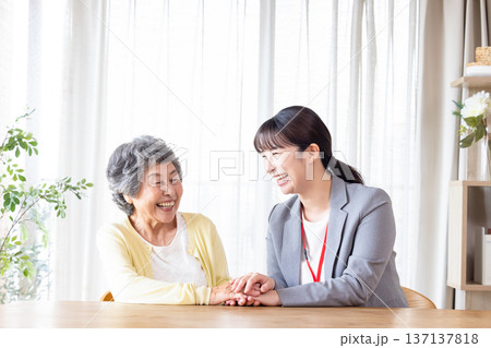 高齢者に寄り添う女性スタッフと笑顔のシニア女性 高齢者に寄り添う女性スタッフと笑顔のシニア女性 137137818