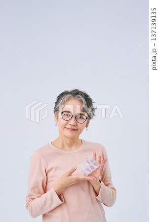 薬の入ったピルケースを持つシニア女性 137139135