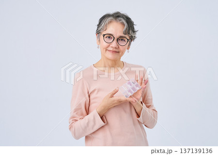 薬の入ったピルケースを持つシニア女性 薬の入ったピルケースを持つシニア女性 137139136