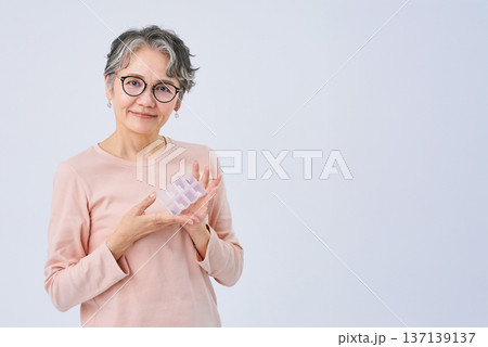 薬の入ったピルケースを持つシニア女性 薬の入ったピルケースを持つシニア女性 137139137