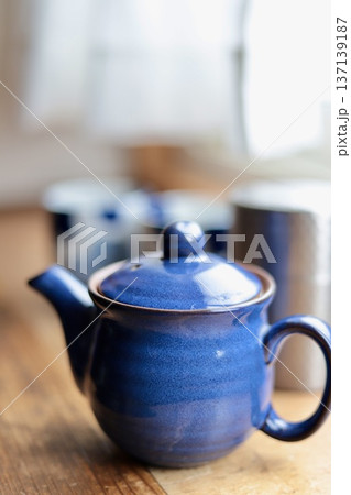 窓辺に置いた日本茶のセット 青い急須と茶筒と湯呑み茶碗 窓辺に置いた日本茶のセット 青い急須と茶筒と湯呑み茶碗 137139187