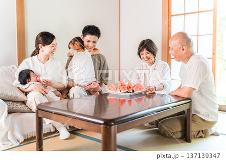 夏休みに里帰りした息子夫婦をスイカでもてなす両親 137139347