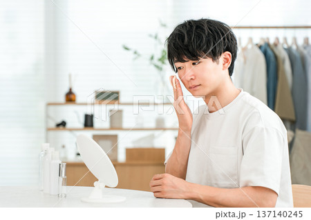 鏡を見ながらスキンケア,フェイスケア,保湿をする若いアジア人男性 鏡を見ながらスキンケア,フェイスケア,保湿をする若いアジア人男性 137140245