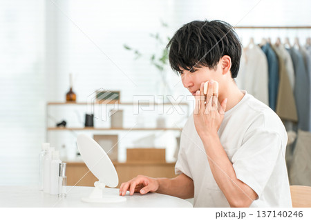 鏡を見ながらスキンケア,フェイスケア,保湿をする若いアジア人男性 137140246