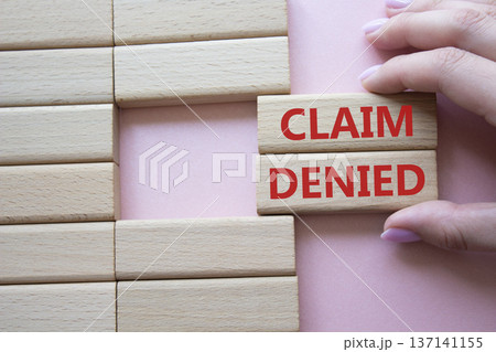 Claim denied symbol. Wooden blocks with words Claim denied. Businessman hand. Beautiful pink background. Business and Claim denied concept. Copy space. 137141155