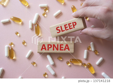 Sleep Apnea symbol. Concept word Sleep Apnea on wooden blocks. Beautiful pink background with pills. Doctor Hand. Medicine and Sleep Apnea concept. Copy space Sleep Apnea symbol. Concept word Sleep Apnea on wooden blocks. Beautiful pink background with pills. Doctor Hand. Medicine and Sleep Apnea concept. Copy space 137141218