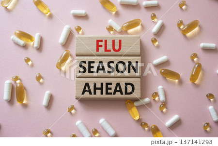 Flu Season Ahead symbol. Concept word Flu Season Ahead on wooden blocks. Beautiful pink background with pills. Medicine and Flu Season Ahead concept. Copy space 137141298
