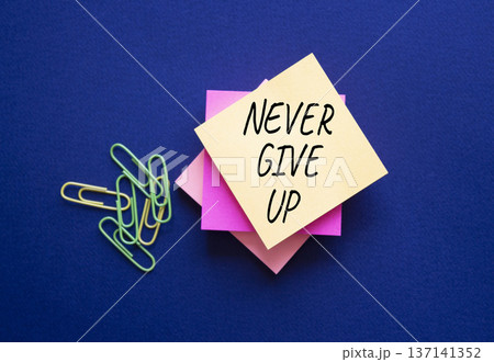 Never give up symbol. Steaky notes with Concept words Never give up. Beautiful deep blue background. Business and Never give up concept. Copy space. Never give up symbol. Steaky notes with Concept words Never give up. Beautiful deep blue background. Business and Never give up concept. Copy space. 137141352
