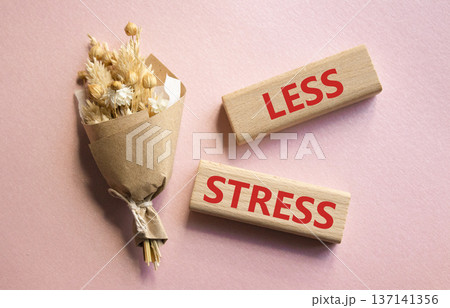 Less stress symbol. Wooden blocks with words Less stress. Beautiful pink background with bouquet of flowers. Healthcare and Less stress concept. Copy space. Less stress symbol. Wooden blocks with words Less stress. Beautiful pink background with bouquet of flowers. Healthcare and Less stress concept. Copy space. 137141356
