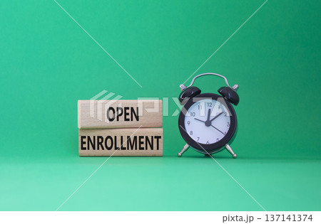 Open Enrollment symbol. Wooden blocks with words Open Enrollment. Beautiful green background with alarm clock. Business and Open Enrollment concept. Copy space. Open Enrollment symbol. Wooden blocks with words Open Enrollment. Beautiful green background with alarm clock. Business and Open Enrollment concept. Copy space. 137141374