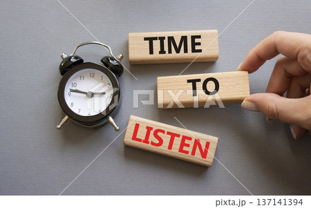 Time to listen symbol. Concept words Time to listen on wooden blocks. Businessman hand. Beautiful grey background with alarm clock. Business and Time to listen concept. Copy space. 137141394
