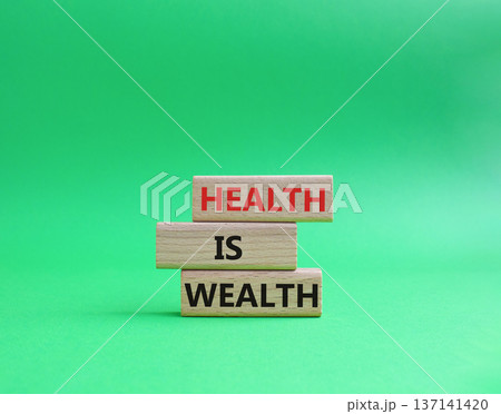 Health is Wealth symbol. Concept word Health is Wealth on wooden blocks. Beautiful green background. Medicine and Health is Wealth concept. Copy space 137141420