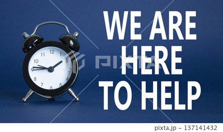 We are here to help symbol. Concept words we are here to help on wooden blocks. Beautiful deep blue background with alarm clock. Business and we are here to help concept. Copy space. We are here to help symbol. Concept words we are here to help on wooden blocks. Beautiful deep blue background with alarm clock. Business and we are here to help concept. Copy space. 137141432