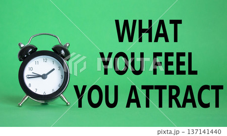 What you Feel you Attract you symbol. Wooden blocks with words What you Feel you Attract. Beautiful green background with alarm clock. Business and What you Feel you Attract concept. Copy space. 137141440
