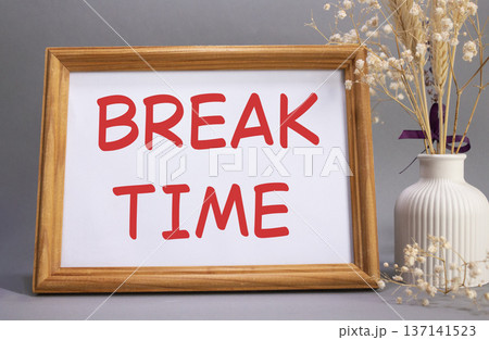 Break Time symbol. Concept words Break Time on beautiful wooden picture frame. Beautiful grey background with flower vase. Business and Break Time concept. Copy space. Break Time symbol. Concept words Break Time on beautiful wooden picture frame. Beautiful grey background with flower vase. Business and Break Time concept. Copy space. 137141523