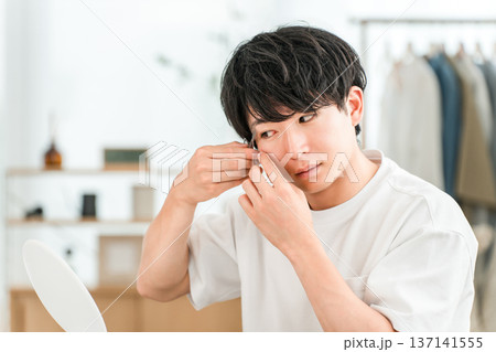 鏡を見ながら眉バサミで眉毛を整える若いアジア人男性 137141555