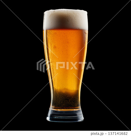 Foamy amber ale beer in a tall glass with creamy foam head, isolated on black background, concept of refreshment and taste 137141682