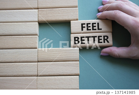 Feel better symbol. Wooden blocks with words Feel better. Businessman hand. Beautiful grey green background. Business and Feel better concept. Copy space. 137141985