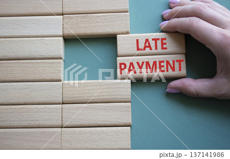 Late payment symbol. Concept word Late payment on wooden blocks. Beautiful grey green background. Businessman hand. Business and Late payment concept. Copy space 137141986