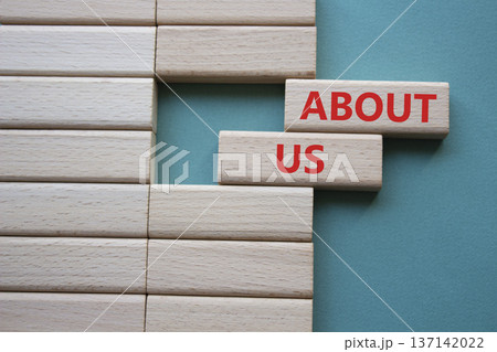 About us symbol. Wooden blocks with words About us. Beautiful grey green background. Business and About us concept. Copy space. 137142022