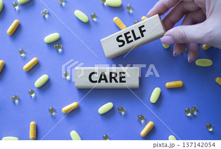 Self Care symbol. Concept word Self Care on wooden blocks. Beautiful purple background with pills. Doctor Hand. Business and Self Care concept. Copy space Self Care symbol. Concept word Self Care on wooden blocks. Beautiful purple background with pills. Doctor Hand. Business and Self Care concept. Copy space 137142054