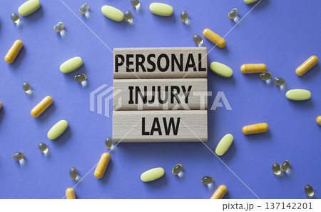 Personal Injury Law symbol. Concept words Personal Injury Law on wooden blocks. Beautiful purple background with pills. Healthcare and Personal Injury Law concept. Copy space. 137142201