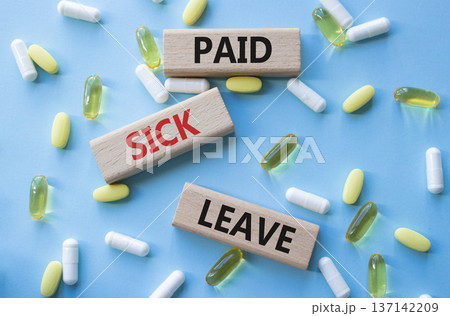 Paid Sick Leave symbol. Concept words Paid Sick Leave on wooden blocks. Beautiful blue background with pills. Healthcare and Paid Sick Leave concept. Copy space. Paid Sick Leave symbol. Concept words Paid Sick Leave on wooden blocks. Beautiful blue background with pills. Healthcare and Paid Sick Leave concept. Copy space. 137142209