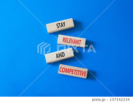 Relevant and Competitive symbol. Concept words Stay Relevant and Competitive on wooden blocks. Beautiful bright blue background. Business and Stay Relevant and Competitive concept. Copy space. 137142234