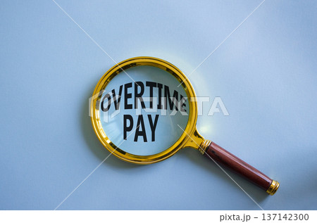 Overtime Pay symbol. Magnifying Glass with words Overtime Pay. Beautiful blue background. Business and Overtime Pay concept. Copy space. Overtime Pay symbol. Magnifying Glass with words Overtime Pay. Beautiful blue background. Business and Overtime Pay concept. Copy space. 137142300
