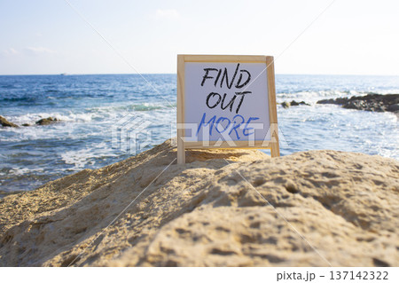 Find out more symbol. White Blackboard with words Find out more. Beautiful sea background. Business and Find out more concept. Copy space. 137142322