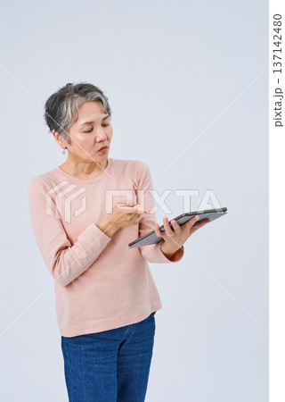 デジタルデバイスを手にするシニア女性 137142480