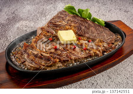 鉄板皿で提供される国産牛のステーキ 137142551
