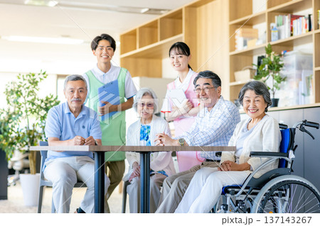 介護施設で寄り添う若いヘルパーとシニア 介護施設で寄り添う若いヘルパーとシニア 137143267