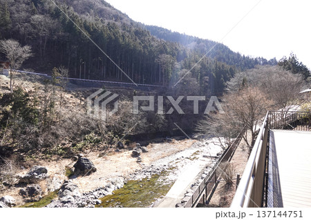 テラスのある施設から見る山間の渓谷とその間を流れる清流の河原 137144751