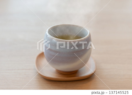 湯呑みから湯気が立ち昇る淹れたての緑茶 湯呑みから湯気が立ち昇る淹れたての緑茶 137145525