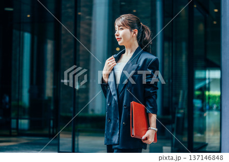 オフィスでスマホを使うスーツ姿の若いビジネスウーマン 137146848