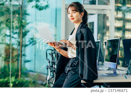 オフィスでパソコンを使って仕事する外国人女性 オフィスでパソコンを使って仕事する外国人女性 137146871