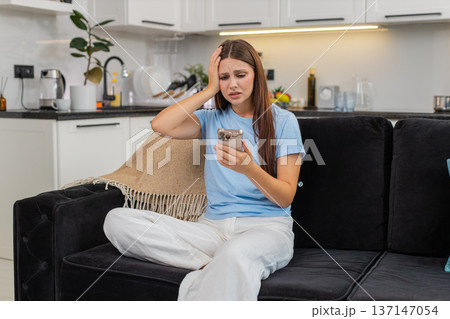 Young woman sees negative alert on smartphone frowns worried says why happened stressed and upset in Young woman sees negative alert on smartphone frowns worried says why happened stressed and upset in 137147054